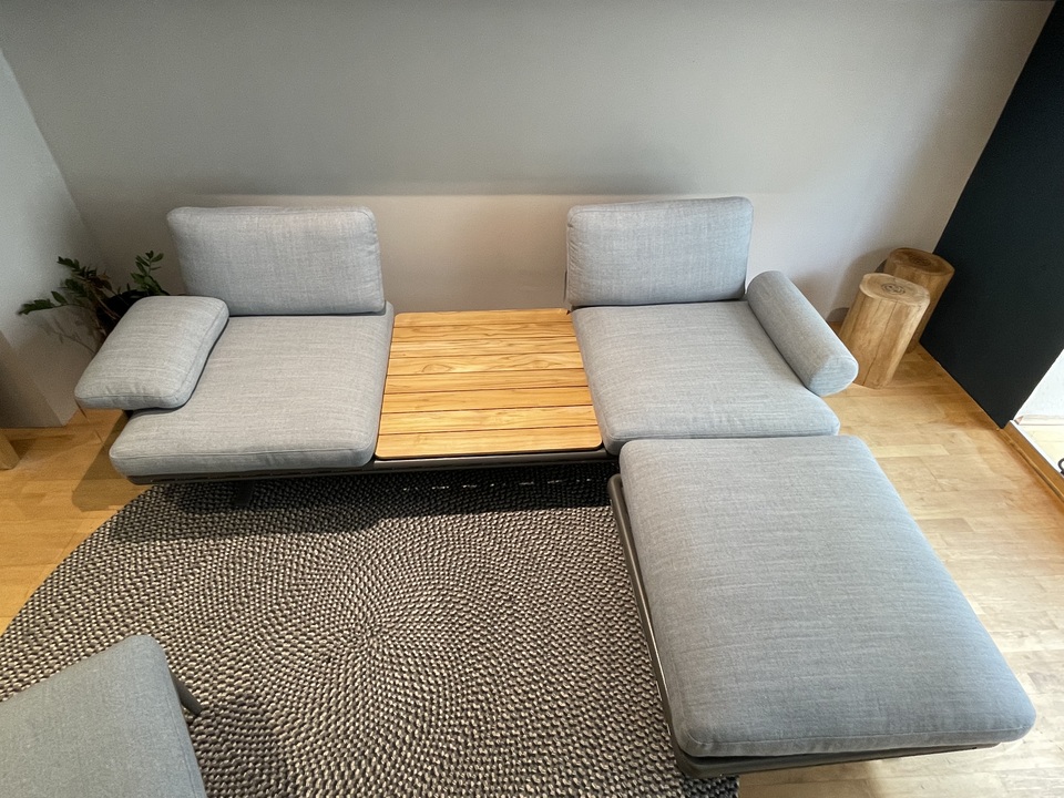 Teile einer Yoko Outdoor Loungesofa Kombination mit Ablage, Sessel und Hocker